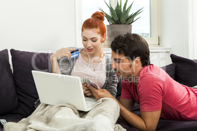 Couple at the Couch with Laptop, Card and Money