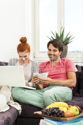 Couple at the Couch with Laptop, Card and Money