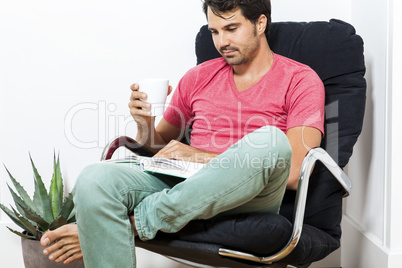 Man Sitting on Chair with Book and a Drink