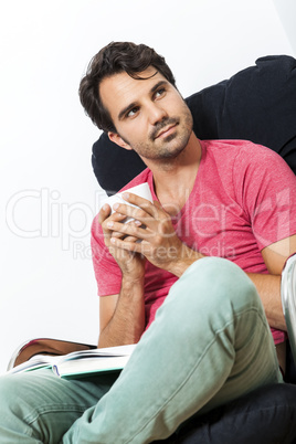 Man Sitting on Chair with Book and a Drink