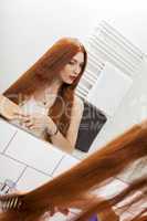 Woman Brushing her Hair In Front a Mirror