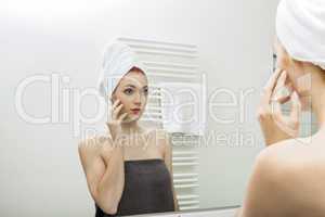 Woman From Shower Looking her Face at the Mirror