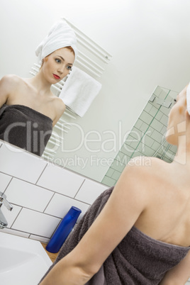 Woman From Shower Looking her Face at the Mirror