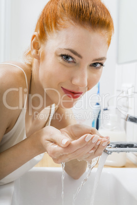 Woman Washing her Face While Looking at the Camera