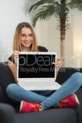 Mädchen sitzt Zuhause am Laptop