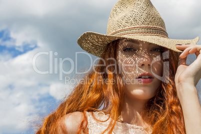 Gorgeous Woman in Hat on Cloudy Sky background