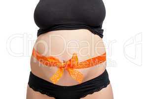 Pregnant woman wearing a bow on her belly