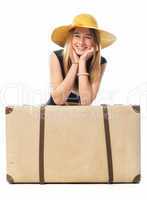 Mädchen mit Hut sitzt vor einem Koffer