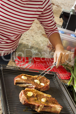 Attractive blond woman barbecuing meat