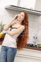 Happy Woman Talking Through Phone at the Kitchen