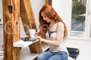 Sitting Woman with a Glass of Drink and a Tablet