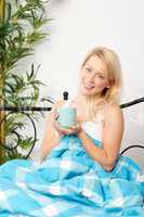 Blonde Frau genießt ersten Kaffee im Bett