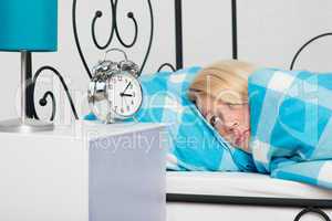 Blonde Frau im Bett mit Schlafproblemen