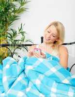 Frau im Bett simst mit Handy