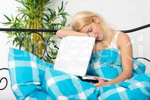 Frau mit Laptop im Bett ist eingeschlafen