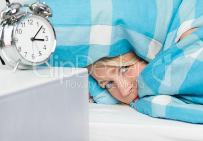Blonde Frau liegt schlaflos im Bett