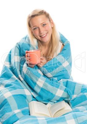 Blonde Frau mit Kaffee und Buch im Bett