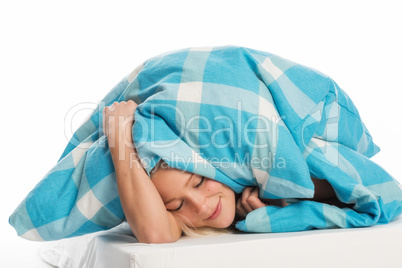 Frau schlummert unter der Bettdecke