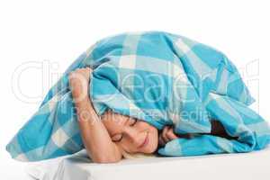 Frau schlummert unter der Bettdecke