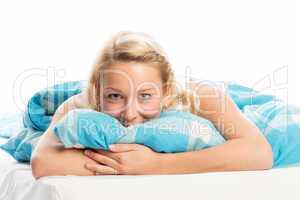 Blonde Frau liegt entspannt im Bett