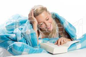 Blonde Frau liest im Bett ein Buch