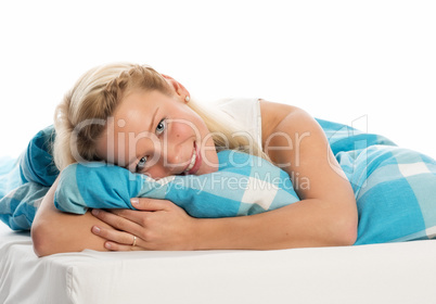 Junge Frau kuschelt sich ins Bett