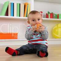 Kleines Baby isst eine Orange Frucht