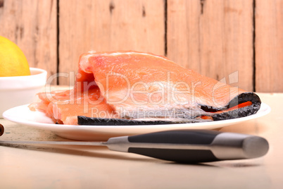 Slice of red fish salmon with knife abd lemon