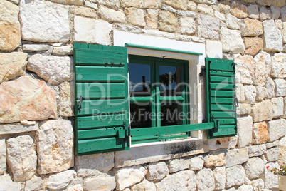 Built Old windows with shutters in a wall of stone