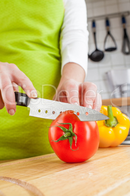Woman's hands cutting tomato