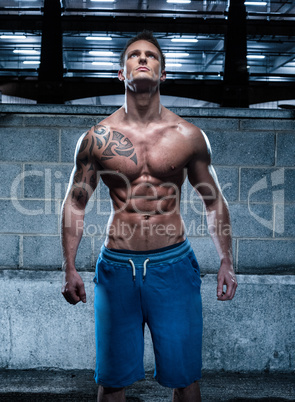 Handsome Athletic Young Man with Tattoo Looking Up