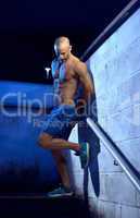 Bald Athletic Man Leaning on Wall with Leg Bent