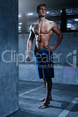 Young Fit Man Standing in a Building Looking up