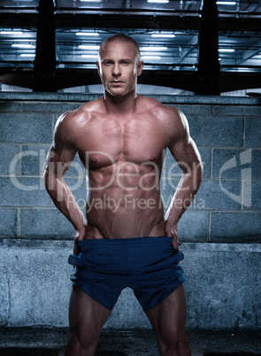 Sexy Bald Young Man Standing in a Rustic Building