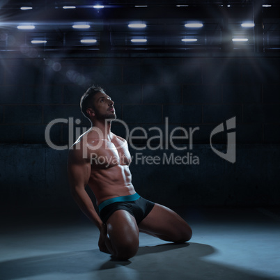 Sexy Thoughtful Athletic Man Kneeling on the Floor