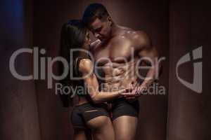 Romantic Bodybuilding Couple Against Wooden Wall