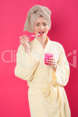 Frau im Bademantel beim Zähneputzen