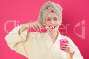 Frau im Bademantel beim Zähneputzen