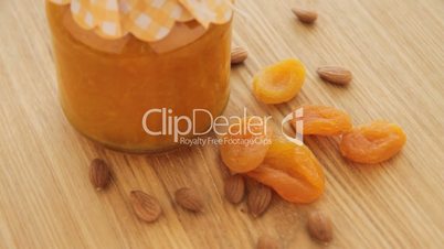 Dried apricot with nuts and jam turn on wood plate, left