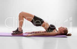 Attractive woman do fitness exercise on a lilac mat