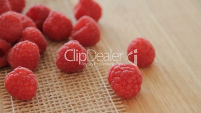 Ripe raspberries on wooden background turns, video