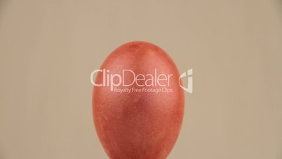 Pink egg rotates and shows contented face, video
