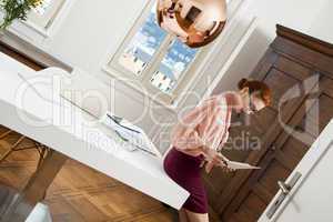 Standing Young Office Woman Writing on a Desk
