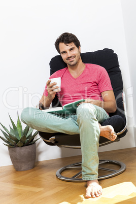 Man Sitting on Chair with Book and a Drink