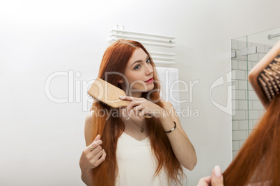 Woman Brushing her Hair In Front a Mirror