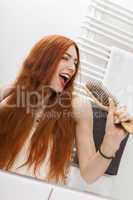 Woman Brushing her Hair In Front a Mirror