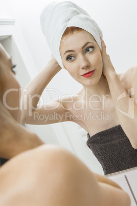 Woman From Shower Looking her Face at the Mirror