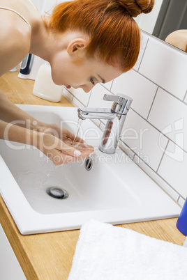 Woman Washing her Face While Looking at the Camera