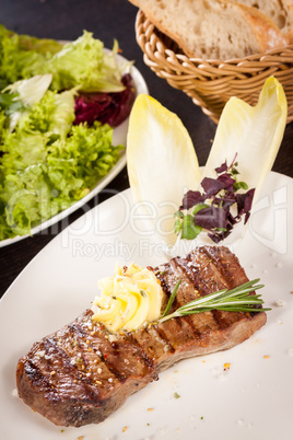 Grilled beef steak topped with butter and rosemary