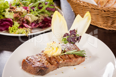 Grilled beef steak topped with butter and rosemary